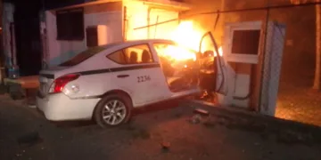 Taxi arde junto a cárcamo tras impacto; conductor es retirado con lesiones