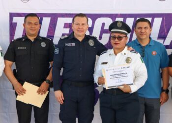Policías municipales posan con un reconocimiento durante el evento Tu Escuela en Azul