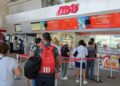 Pasajeros hacen fila en las taquillas de ADO en Cancún.