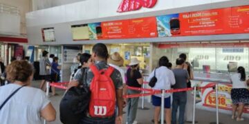 Pasajeros hacen fila en las taquillas de ADO en Cancún.