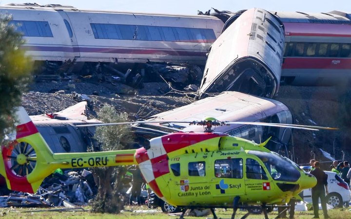 Vagones descarrilados y un helicóptero de emergencias en el lugar del choque de trenes cerca de Urda, Toledo