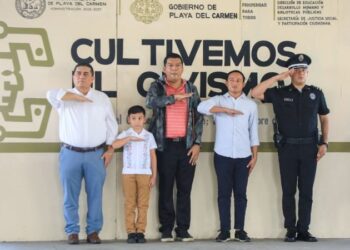 Autoridades de Playa del Carmen y una integrante del Cabildo Infantil rinden honores a la bandera en el programa Cultivemos el Civismo