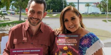 Bernardo Cueto Riestra y Mara Lezama sostienen el cartel del Primer Encuentro de Cocineras Tradicionales de Quintana Roo