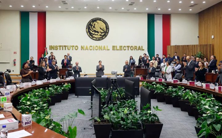 Consejeros y representantes de partidos aplauden de pie en la sala del Consejo General del INE en homenaje a Cuauhtémoc Cárdenas