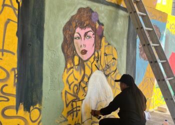 Artista urbana pinta un mural en el muro bajo el puente de López Portillo y Bonampak, en Cancún, donde se exhibía el Museo de los Hampones