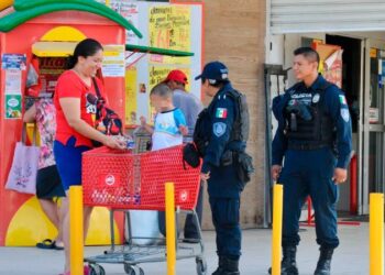 Policías platican con una familia frente a un comercio, imagen de archivo sobre percepción de inseguridad en Cancún