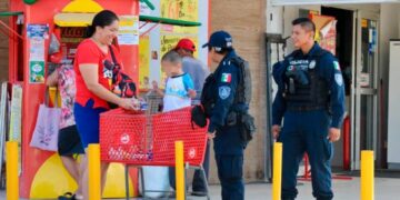 Policías platican con una familia frente a un comercio, imagen de archivo sobre percepción de inseguridad en Cancún