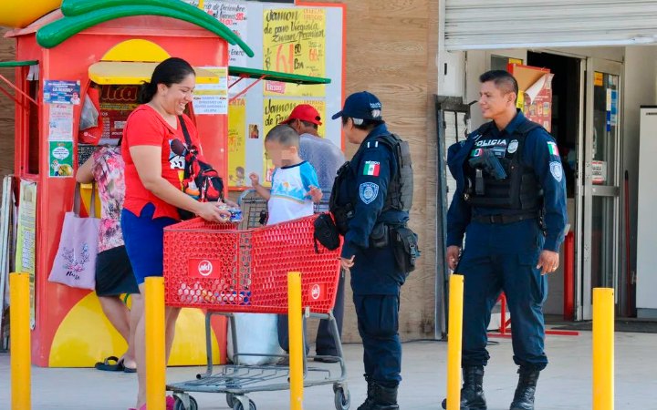 Policías platican con una familia frente a un comercio, imagen de archivo sobre percepción de inseguridad en Cancún