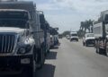 Camiones de transportistas estacionados en un carril de la carretera 307 en Cancún.