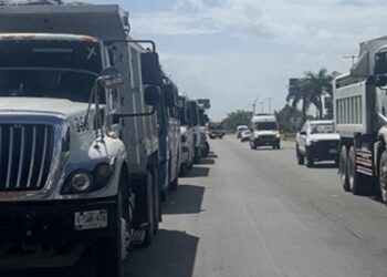 Camiones de transportistas estacionados en un carril de la carretera 307 en Cancún.