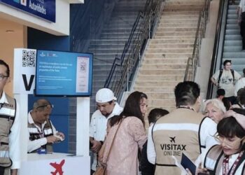 Módulo de cobro del Visitax en un aeropuerto de Quintana Roo, con personal atendiendo a turistas.