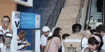 Módulo de cobro del Visitax en un aeropuerto de Quintana Roo, con personal atendiendo a turistas.