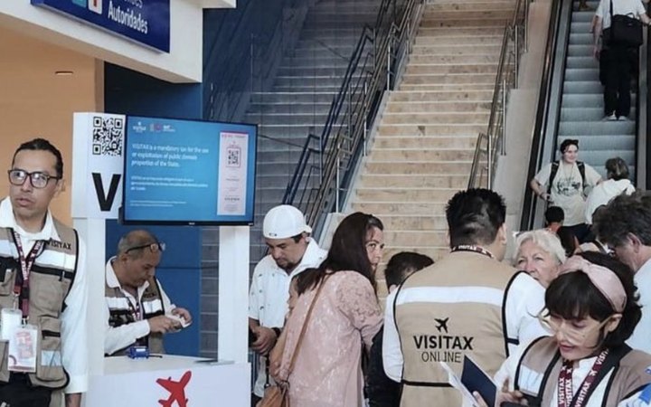 Módulo de cobro del Visitax en un aeropuerto de Quintana Roo, con personal atendiendo a turistas.
